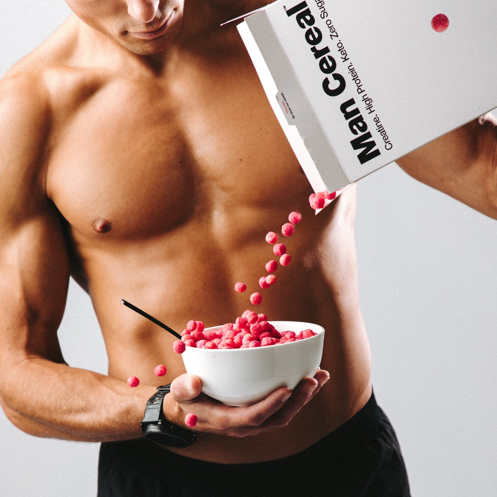 Man pouring cereal into a bowl labeled 'Man Cereal' with a white background